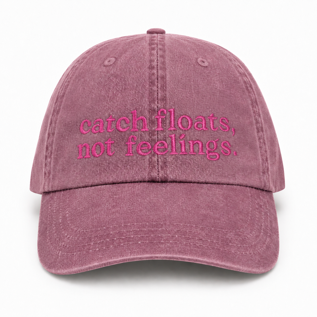 Pink cap with 'catch floats, not feelings' text on a white background