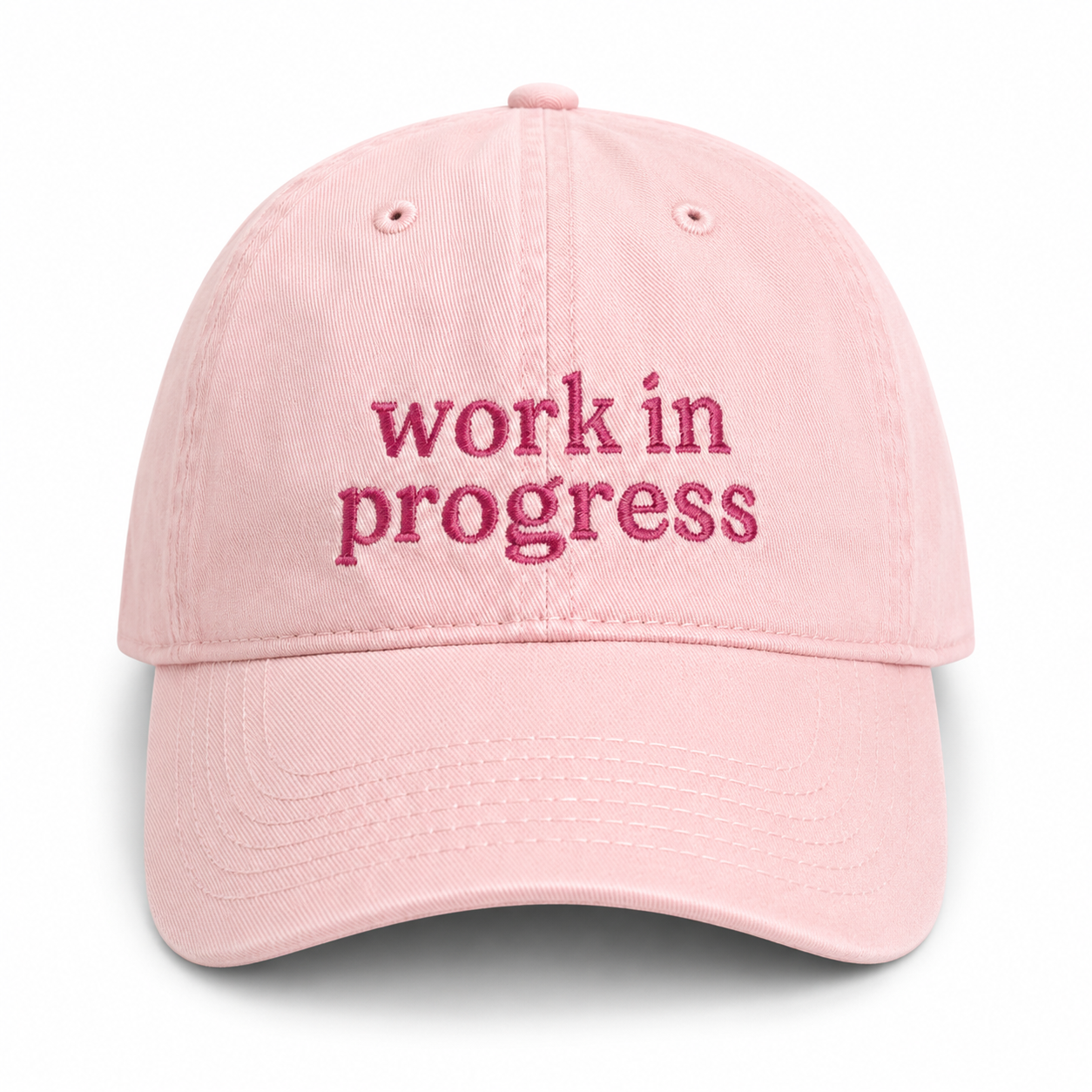 Pink cap with 'work in progress' text on a white background