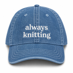 Blue denim cap with 'always knitting' text on a white background
