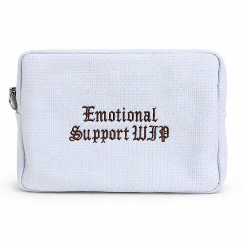 A light blue textured canvas zippered pouch with the words 'Emotional Support WIP' embroidered in a dark brown gothic font on the front, set against a plain white background.