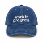 Blue cap with 'work in progress' text on a white background
