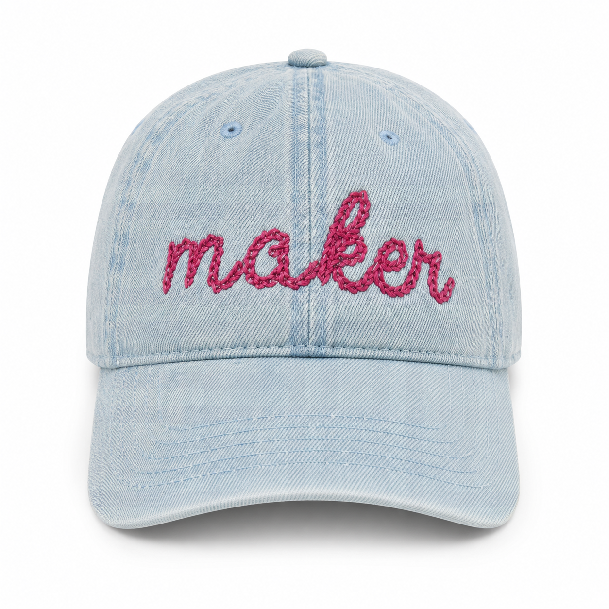 Light blue denim cap with 'maker' embroidered in pink on a white background