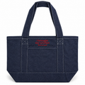 A dark indigo denim tote bag with white contrast stitching, featuring a front pocket with red embroidered text that reads 'I brought my crochet (but in blue)'.