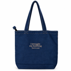 A dark blue denim tote bag with two shoulder straps, featuring the embroidered text 'i brought my knitting (just in case)' in light beige on the front, set against a plain white background.