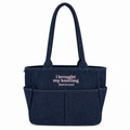 A navy blue canvas tote bag with two top handles and front pockets, featuring the white embroidered text 'i brought my knitting (just in case)' on the front, set against a plain white background.