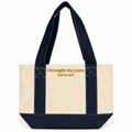 A canvas tote bag with a natural cream body and dark indigo denim straps and base, featuring the text 'i brought my yarn (just in case)' in tan lettering on the front.