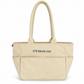 A beige canvas tote bag with dual top handles and the phrase 'it'll block out' printed in navy blue text on the front, set against a plain white background.