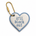 White faux leather heart bag tag with baby blue It’ll Block Out gothic embroidery and gold-tone hardware