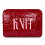 A red crocodile-embossed zippered pouch with the word 'KNIT' in large light pink letters across the front, shown on a plain white background.