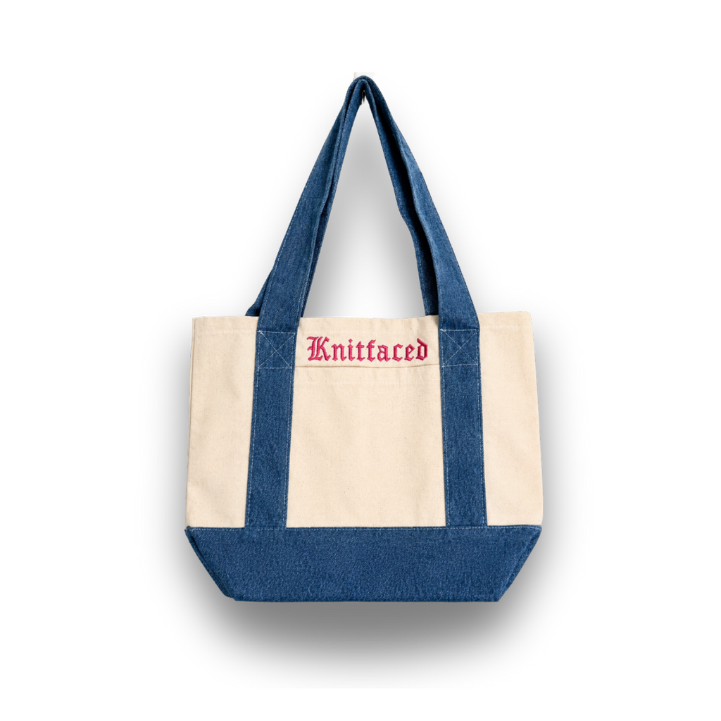 Tote bag with blue top half and beige bottom half, featuring the brand 'Knitfaced'.