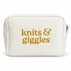 White waffle pouch with metallic yellow gold “Knits & Giggles” embroidery.