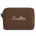 A brown waffle-weave zippered pouch with the word 'Knitter' embroidered in white script across the front, shown on a plain white background.