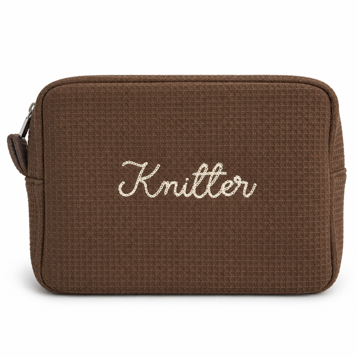 A brown waffle-weave zippered pouch with the word 'Knitter' embroidered in white script across the front, shown on a plain white background.