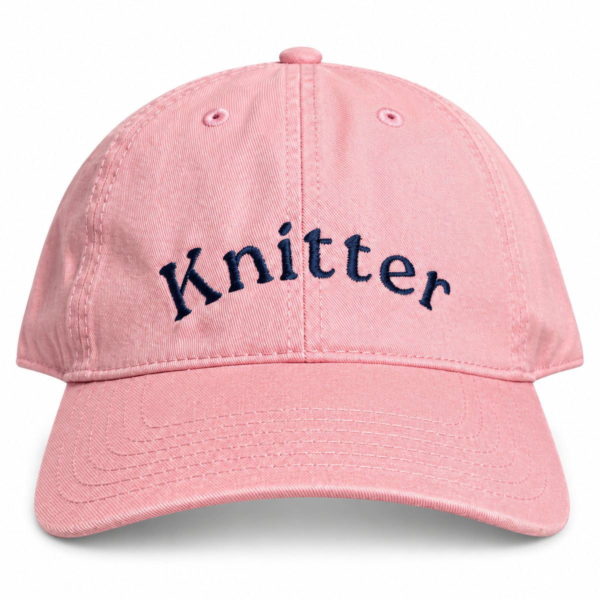 A pink cotton baseball cap with the word 'Knitter' embroidered in navy blue script across the front, shown on a clean white background.