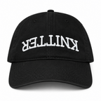 Black hat with white puff embroidered upside-down Knitter lettering