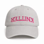 Grey hat with pink puff embroidered upside-down Knitter lettering