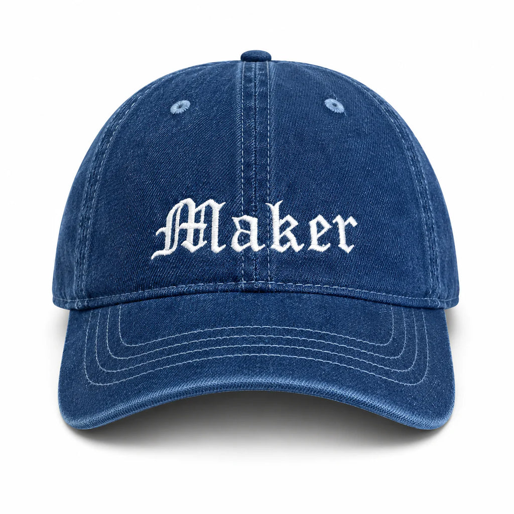 Blue cap with 'Maker' embroidered on a white background