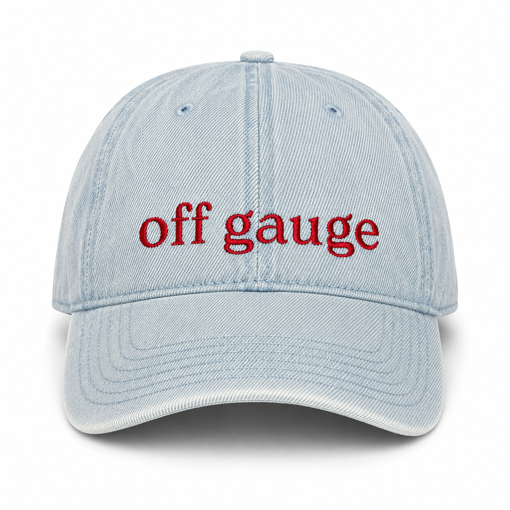 A light blue denim baseball cap with the words 'off gauge' embroidered in red across the front, shown against a plain white background.