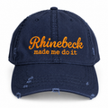 A navy blue distressed baseball cap with orange embroidered text reading 'Rhinebeck made me do it' on the front, shown against a plain white background.