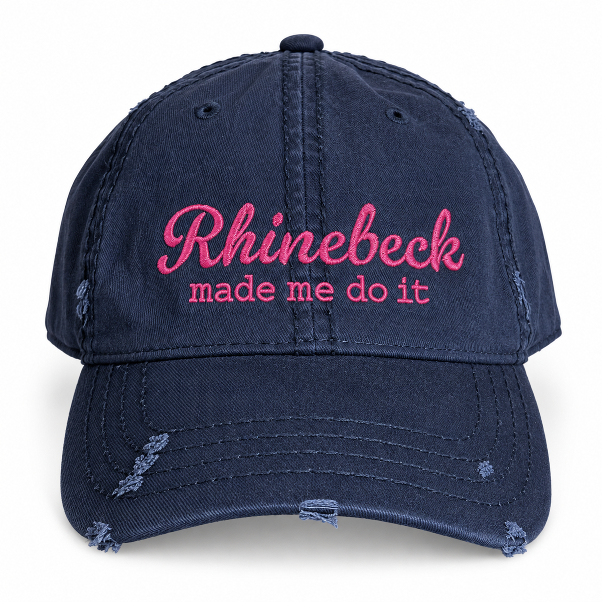 A navy blue distressed baseball cap with pink embroidered text reading 'Rhinebeck made me do it' on the front, shown against a plain white background.