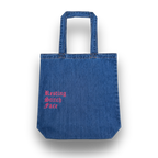 Blue denim tote bag with 'Resting Stitch Face' text in pink on a white background