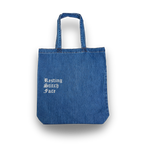 Blue denim tote bag with 'Resting Stitch Face' text on a white background