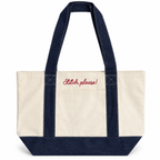 An off-white canvas tote bag with dark navy blue denim-style handles, bottom panel, and side straps, featuring the phrase 'Stitch, please!' embroidered in red script on the front pocket, set against a plain white background.