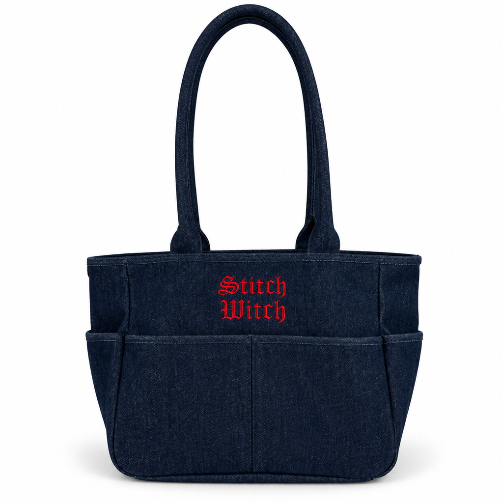 A dark navy blue fabric tote bag with two top handles, multiple front pockets, and 'Stitch Witch' embroidered in red Gothic-style lettering on the front, shown on a plain white background.
