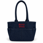 A dark navy blue fabric tote bag with two top handles, multiple front pockets, and 'Stitch Witch' embroidered in red Gothic-style lettering on the front, shown on a plain white background.