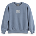 A dusty blue crewneck sweatshirt with 'VARSITY KNITTER' printed in white block letters on the chest, displayed against a clean white background.