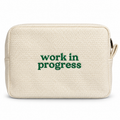 Butter yellow waffle zip pouch with green “Work in Progress” embroidery.