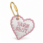 White croc-embossed heart bag tag with pink Yarn Slut embroidery and gold-tone hardware